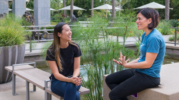 Two women sitting outside our Intuit office location in San Diego talking to one another