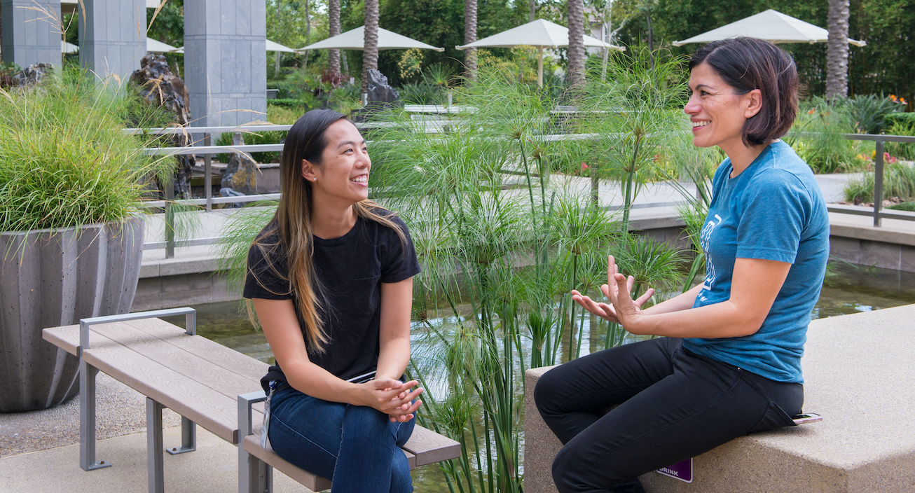 Two women sitting outside our Intuit office location in San Diego talking to one another