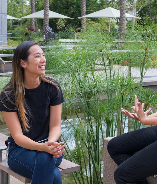 Two women sitting outside our Intuit office location in San Diego talking to one another