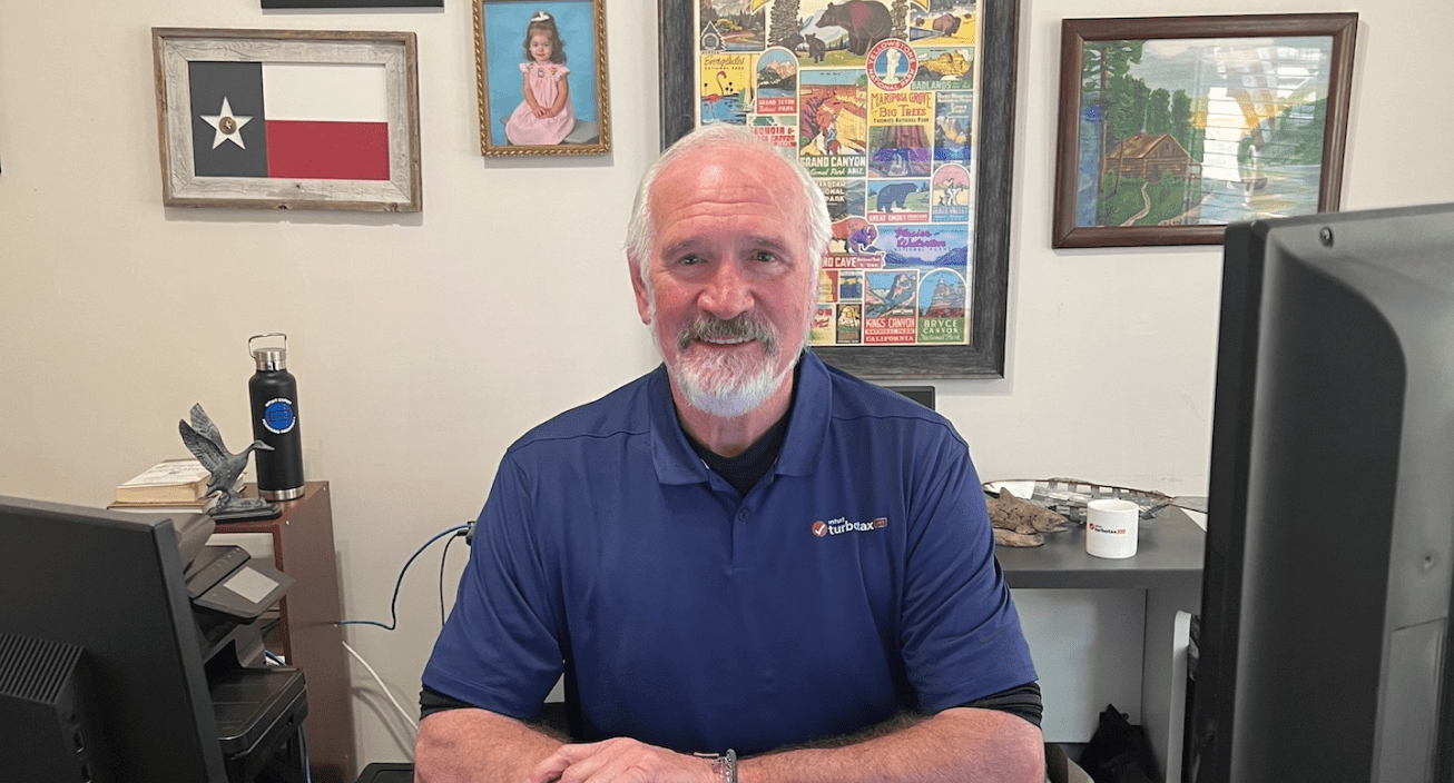 Kent Abney, Intuit tax expert looking at the camera from his desk at home and smiling