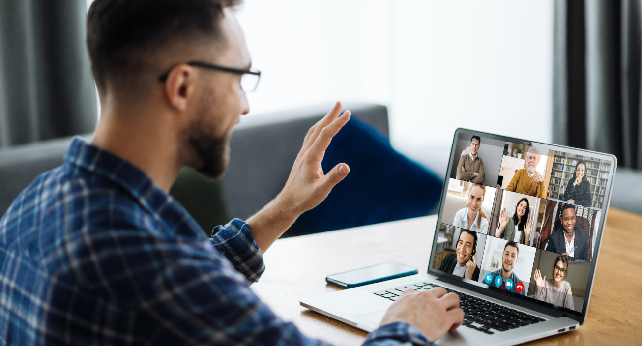 Man waving at a computer while on a video conference call