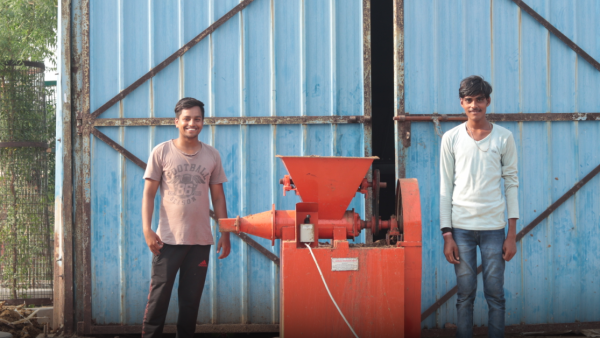 Two students in India smile in front of the camera