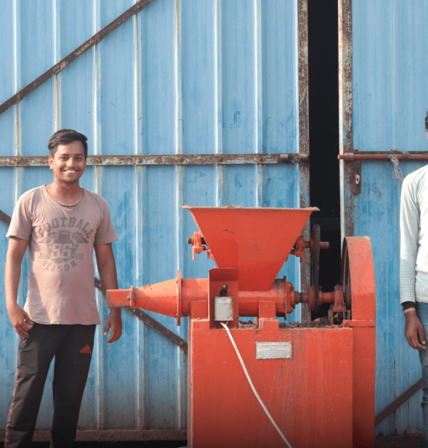 Two students in India smile in front of the camera