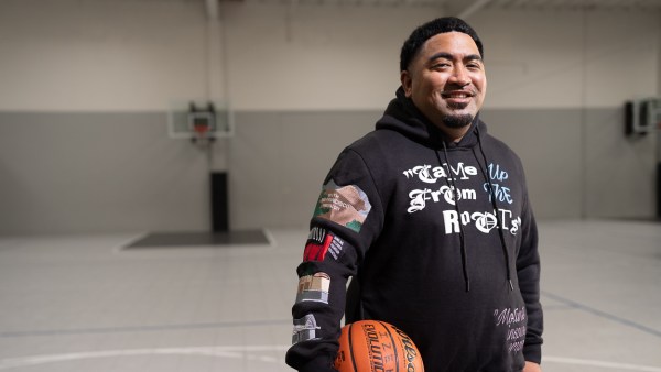 Fale Malepeai, Credit Karma customer and basetball coach holding a basketball smiling at the camera