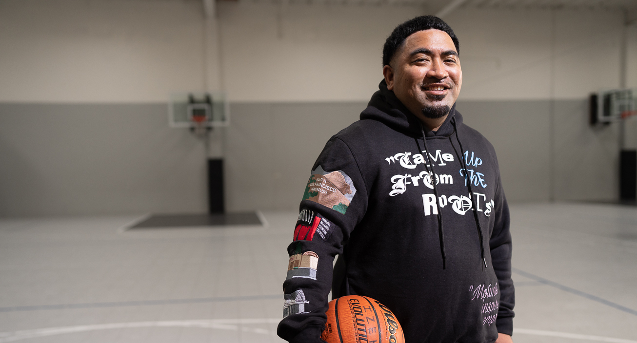 Fale Malepeai, Credit Karma customer and basetball coach holding a basketball smiling at the camera