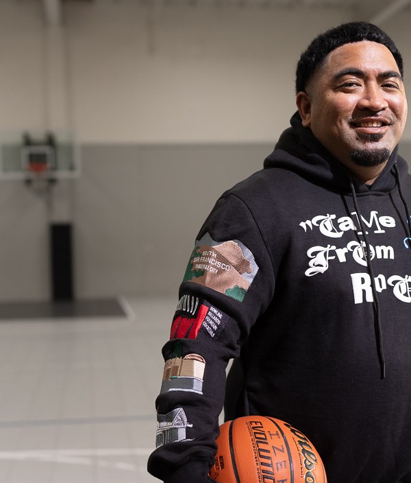 Fale Malepeai, Credit Karma customer and basetball coach holding a basketball smiling at the camera