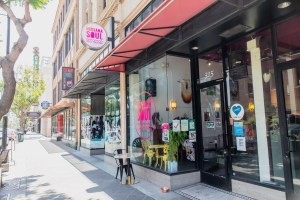 Exterior of a downtown coffee shop with a pink awning.