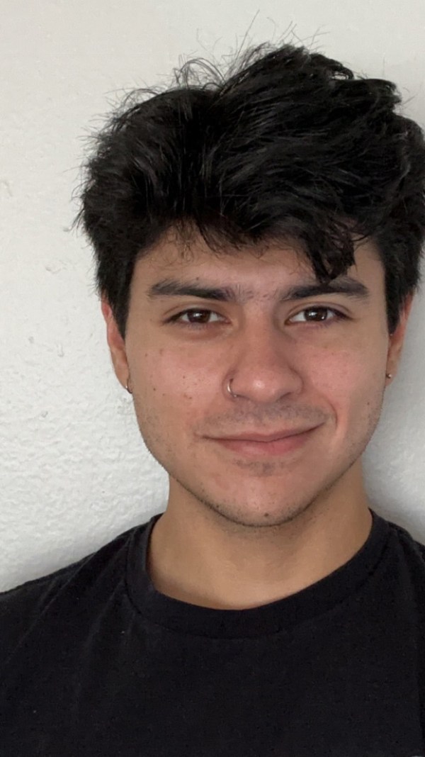 German Flores, an Intuit software engineer smiles for the camera against a white background