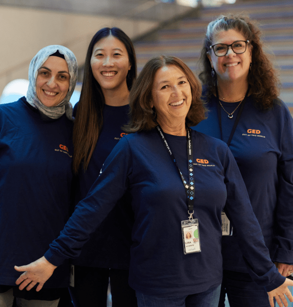 Four engineers pose for a photo at the Intuit campus wearing dark blue shirts with the GED logo.