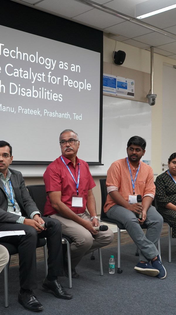 A diverse group of people on stage with a background reading, "Technology as an innovative catalyst for people with disabilities.: