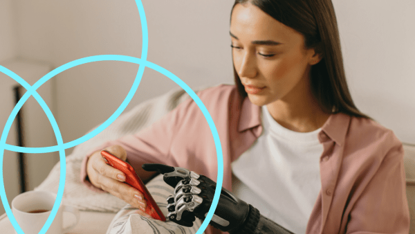 A young woman with brown hair uses her smartphone with a robotic prosthetic hand.