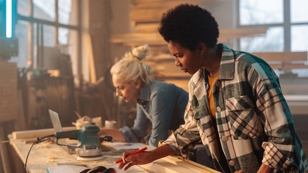 Two women working on a table together.