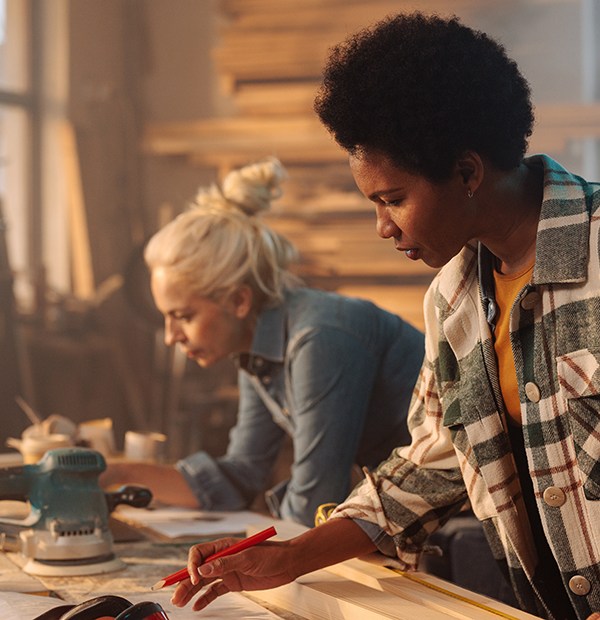 Two women working on a table together.