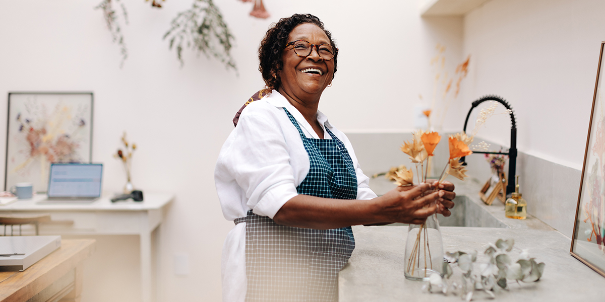 A Black, female business owner poses in her luxury floral shop.