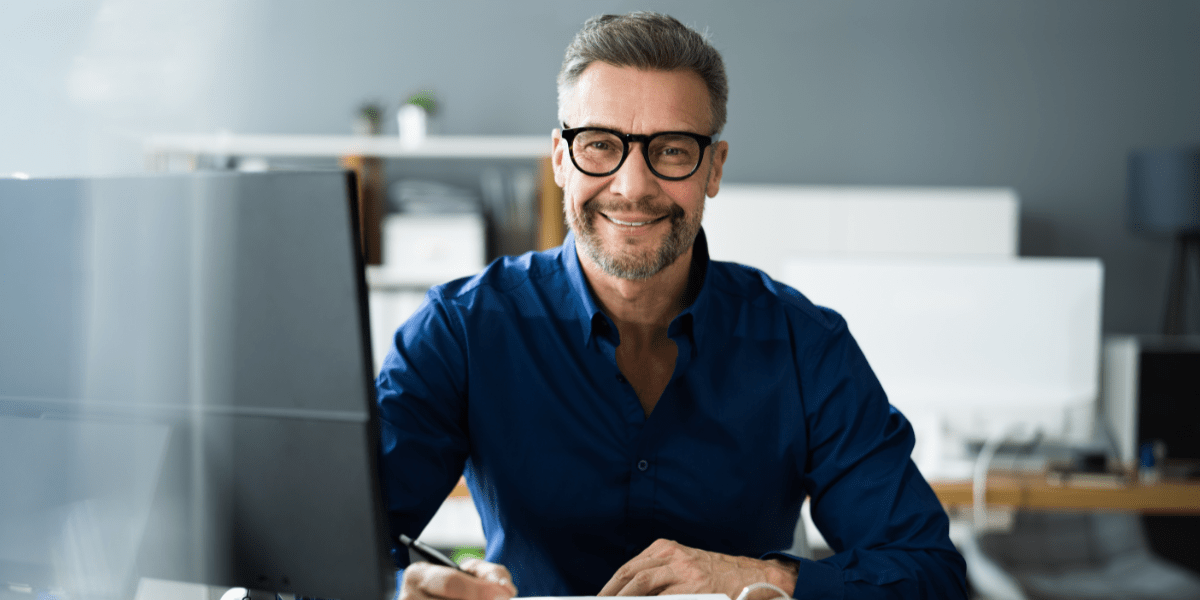 A man reviews financial documents, illustrating the difference between bookkeeping and accounting careers.