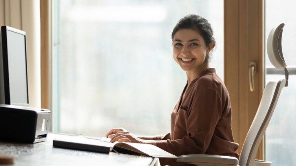 A woman reviews bookkeeping tips and an example resume.