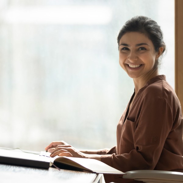 A woman reviews bookkeeping tips and an example resume.